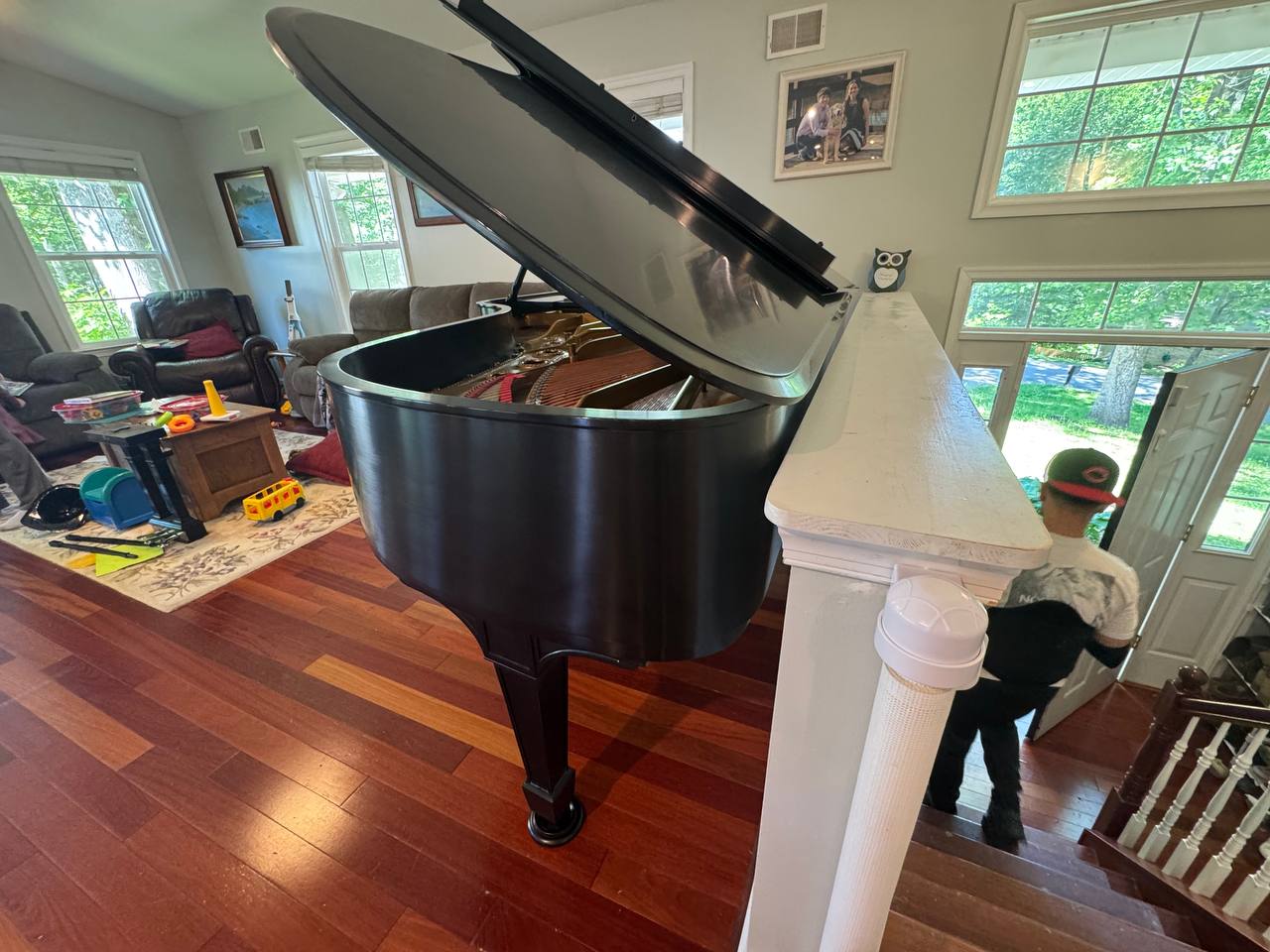 Grand piano in a home beside the entrance staircase