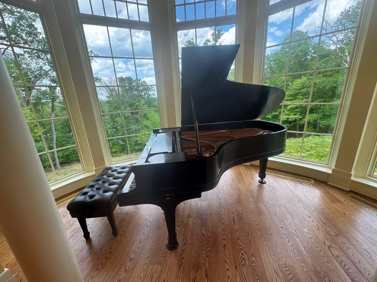 Grand piano beside tall windows in a home